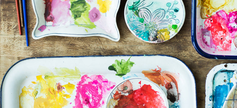 Artist paints and brushes on ceramic dishes