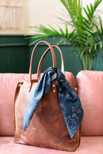 Load image into Gallery viewer, Navy blue animal print scarf bandana tied on leather handbag
